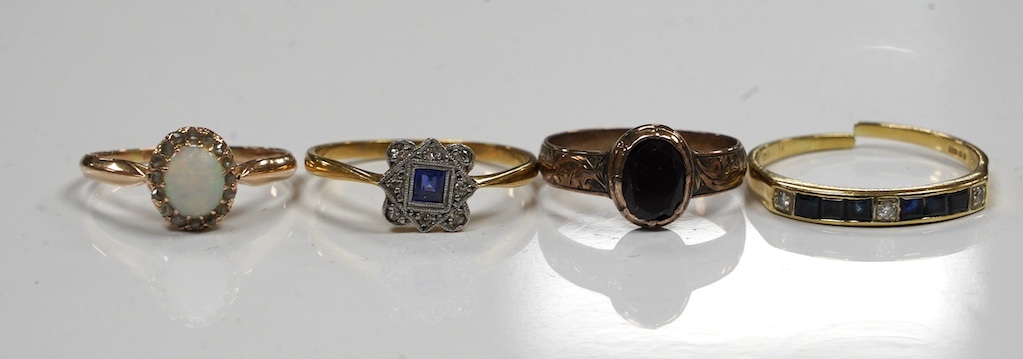 Four assorted gem set rings, including 18ct and plat, sapphire and diamond cluster, 14k, white opal and diamond cluster, an 18ct sapphire and diamond (cut) and an antique garnet set yellow metal ring. Condition - poor to